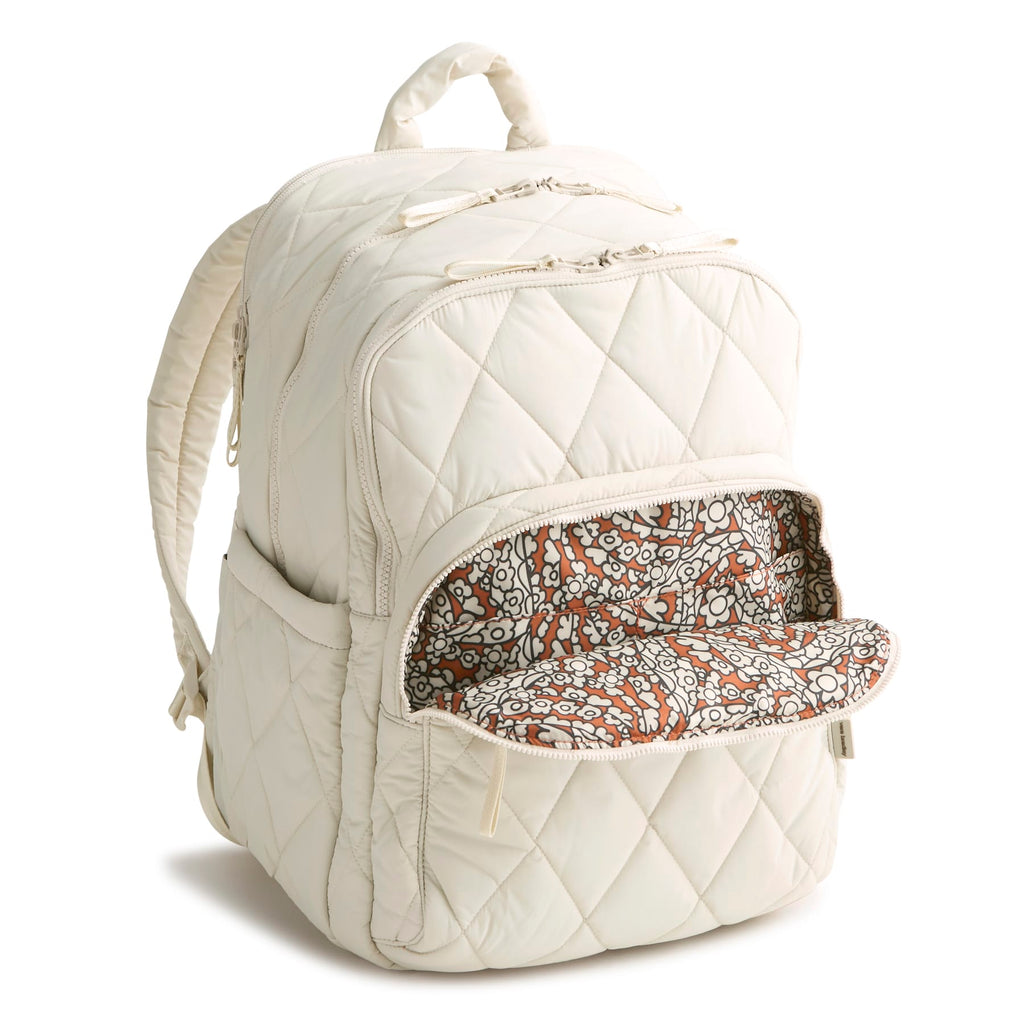Quilted white backpack with a floral patterned pocket on a white background