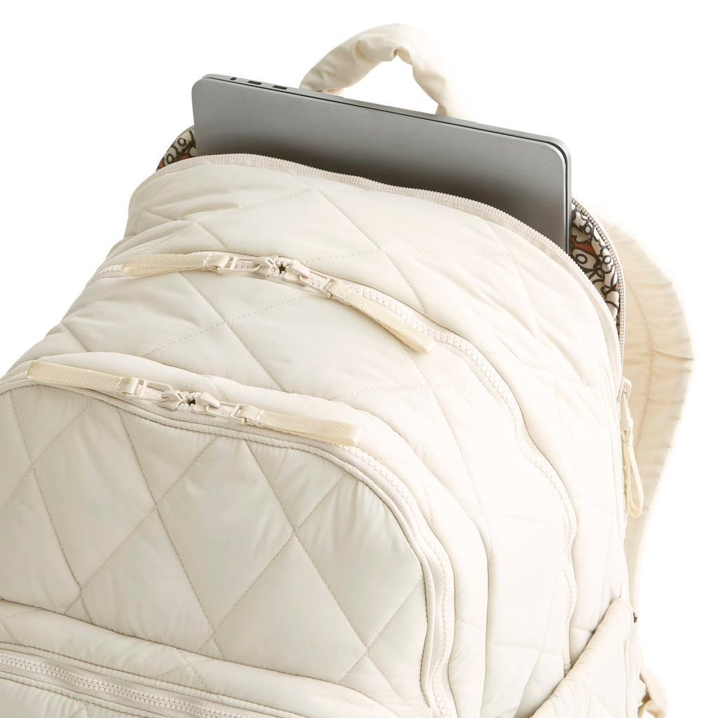 White quilted backpack with a tablet inside on a white background