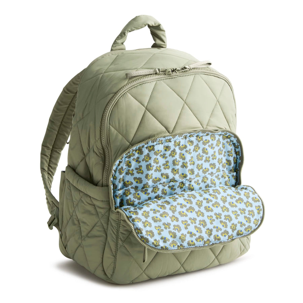 Quilted green backpack with floral interior pocket on a white background