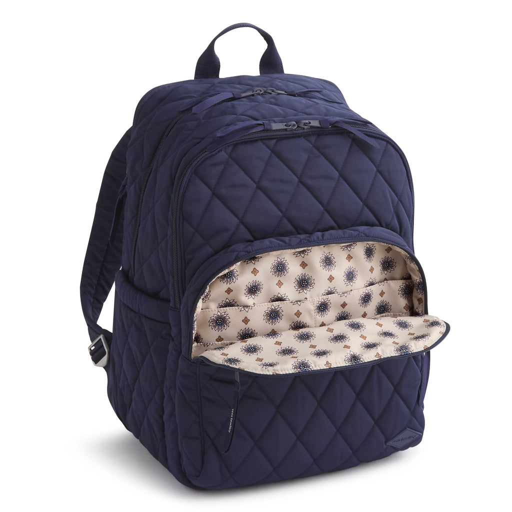 Navy blue quilted backpack with floral interior lining on a white background